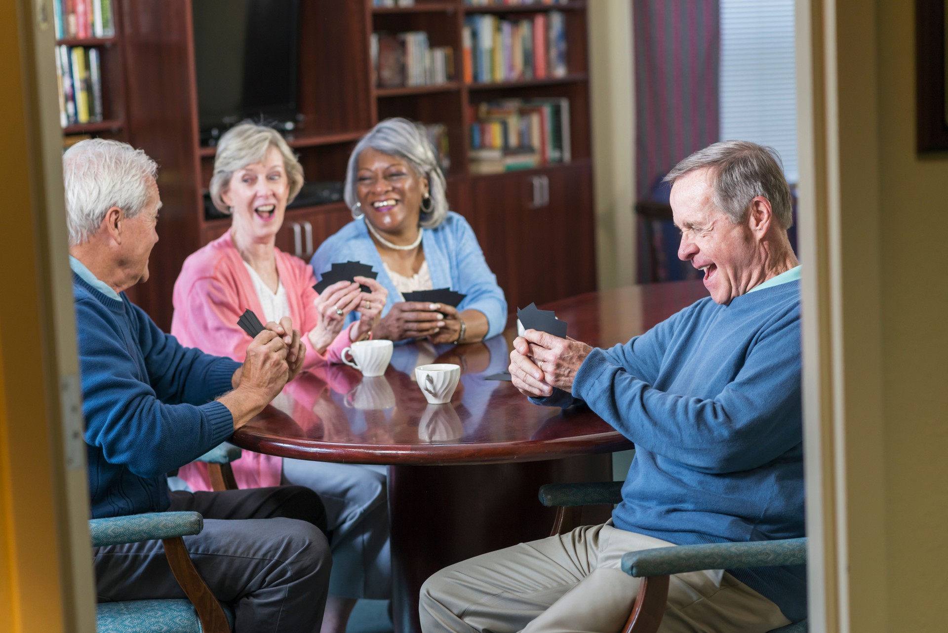 Multi-ethnic group of seniors playing card game