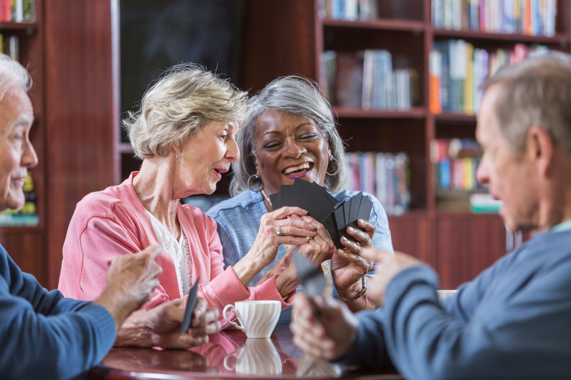 Multiracial group of seniors talking, playing card game
